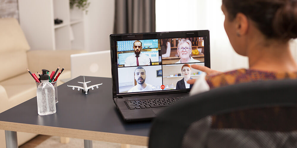 A legal professional in her home office participates in a remote work conference call with her colleagues.