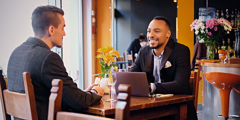 Photo of an attorney having lunch with a client and gathering rankings information that will support law firm development.