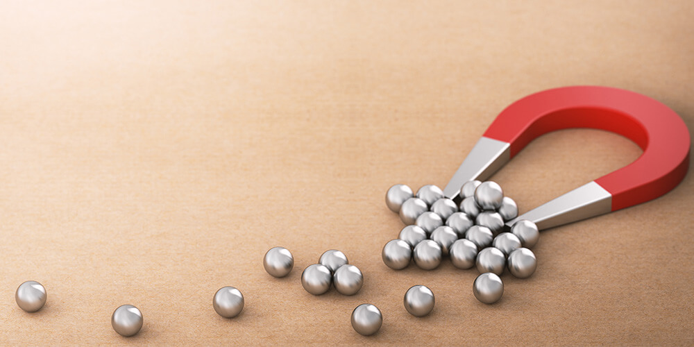 Photo of a magnet attracting metal marbles illustrates the concept of lead generation for lawyers.