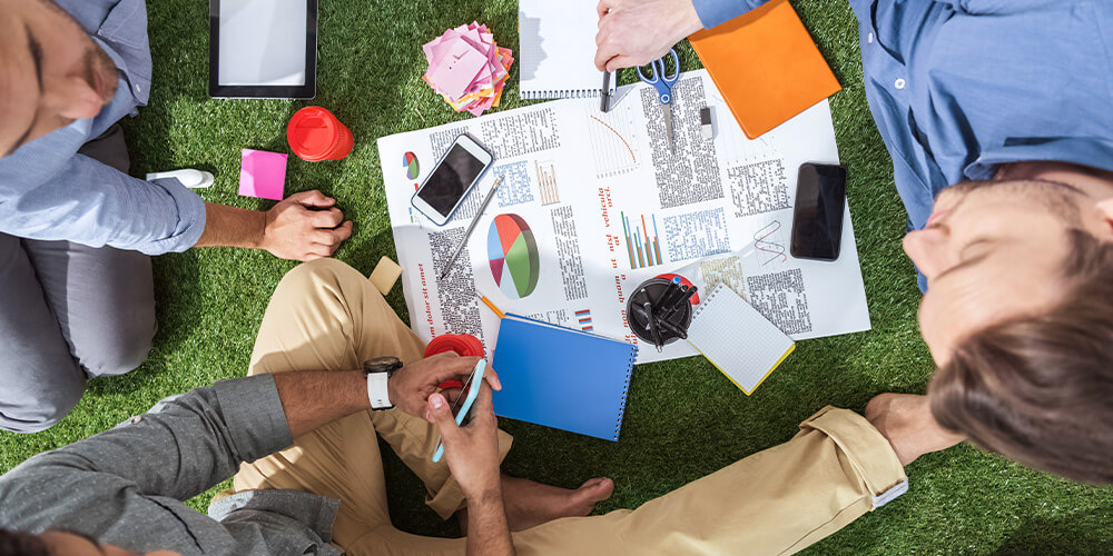 A group of employees reviews data and reports during a law firm strategic planning session.