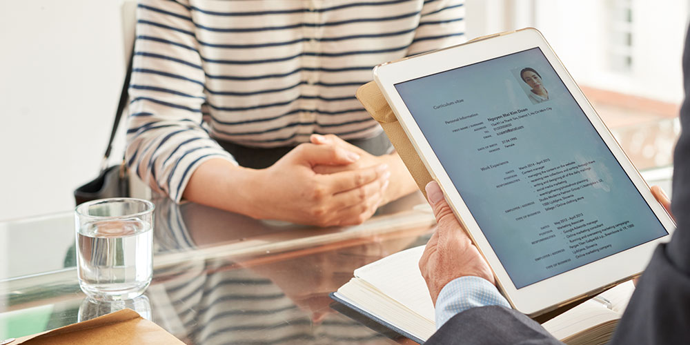 Photo of a prospective employer reading a lawyer’s resume, which was not crafted using our legal resume writing tips.