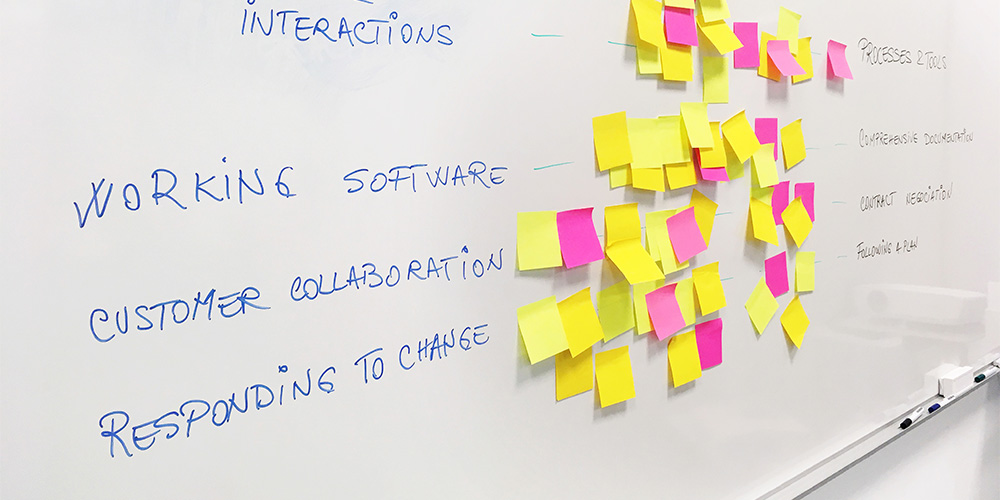 A white board and numerous sticky notes show how a law firm can work to improve the agility of their legal operations.