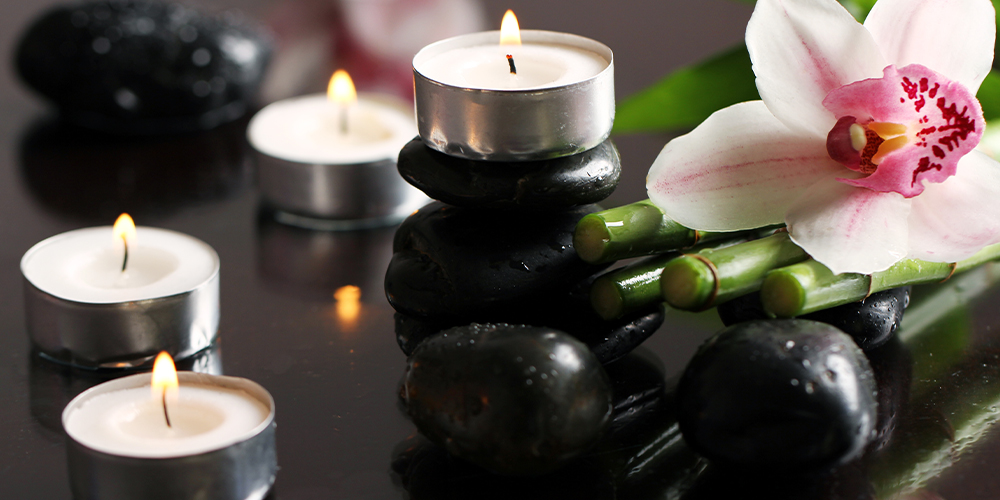 Photo of hot rocks and traditional spa decor, illustrating the topic of self-care and wellness for court reporters.