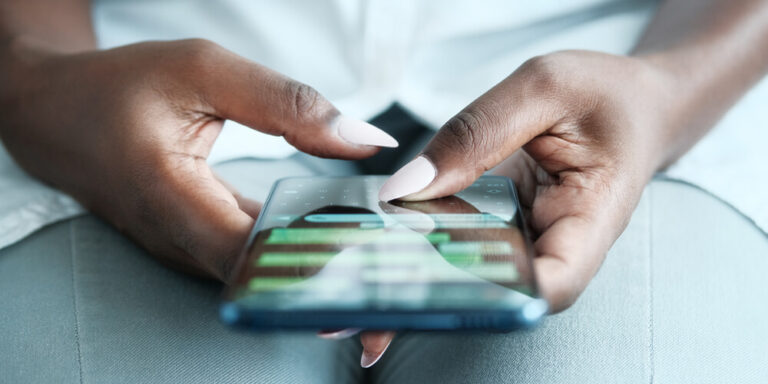 Photo of a woman’s hands using her cellphone to send and receive ephemeral messages, which will complicate the digital forensics process.